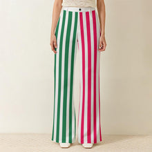 Load image into Gallery viewer, A pair of Lollipop Lady striped trousers with one pink leg and one green leg
